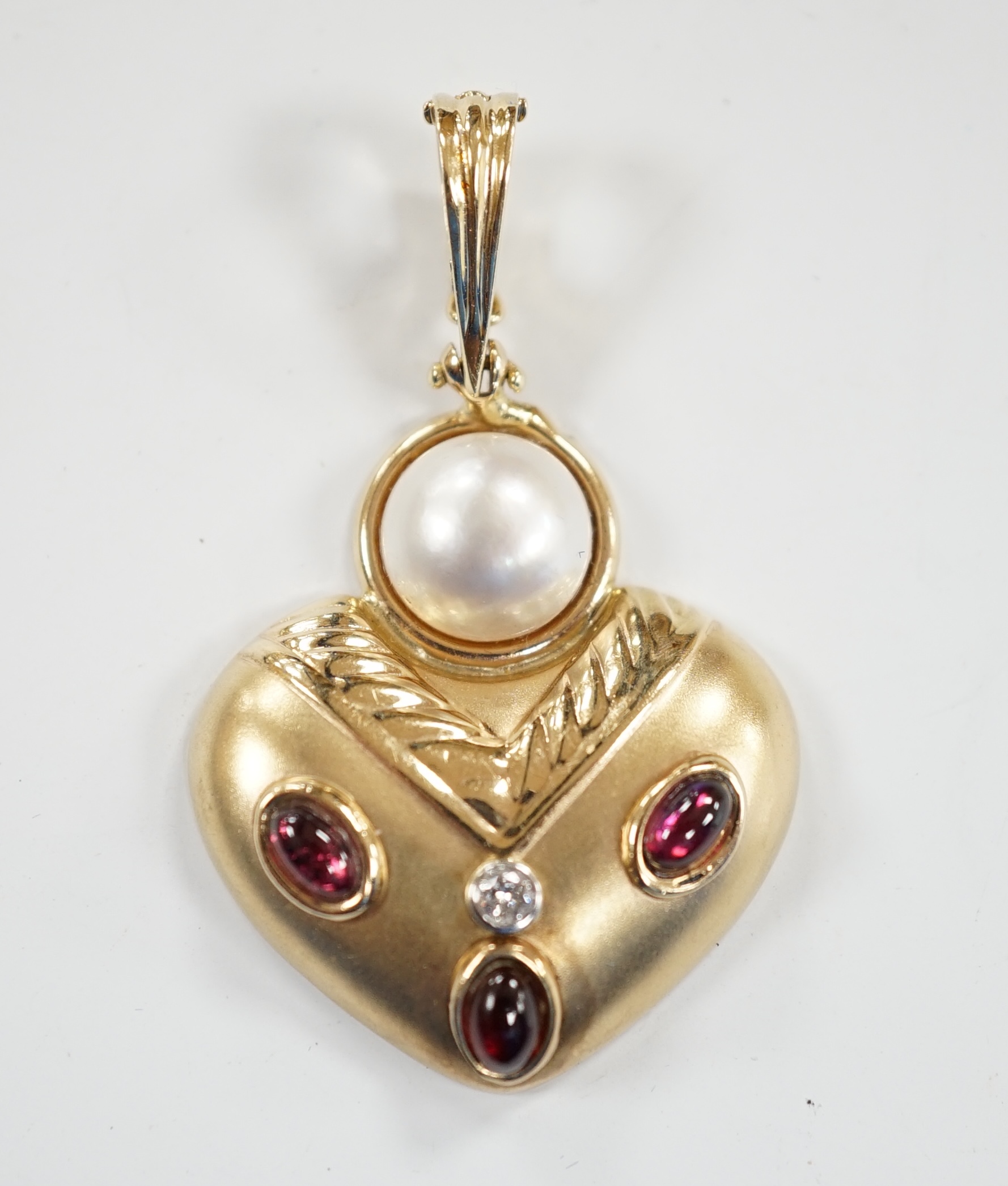 A modern unmarked yellow metal, mabe pearl, cabochon garnet and diamond set pendant, width 28mm, gross weight 5.6 grams.